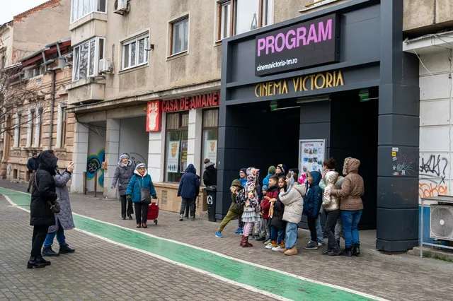 Copii caută filmul lor preferat în programul din fața Cinema Victoria 